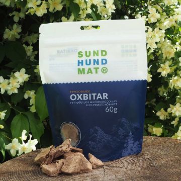 Oxbitar från Sund Hundmat - ett naturligt hundgodis Frystorkade oxbitar från Sund hundmat kommer i en praktisk återförslutningsbar påse. Oxbitarna är lite oregelbunda i sin form. Påsen är blå och vit.