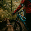 Hunden har Orbiloc dual i frägen amber runt halsen och husse står med cykeln redo med Orbiloc dual i färgen svart runt armen.