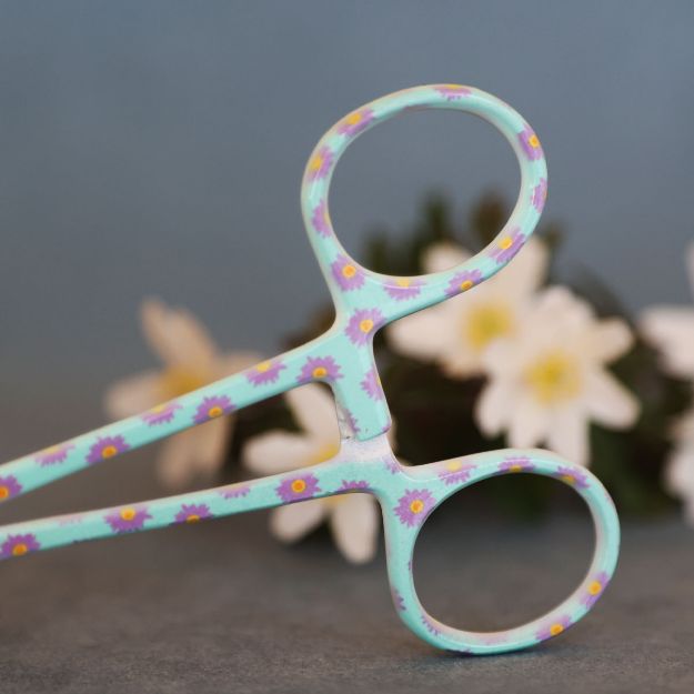 Handtaget är blått med lila små blommor på.