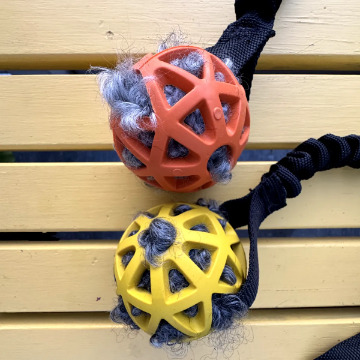 Visa detaljer för Sune gallerboll med fårskinn inuti och expander Hundleksak med gallerboll och fårskinn inuti bollen, orange boll och gul boll